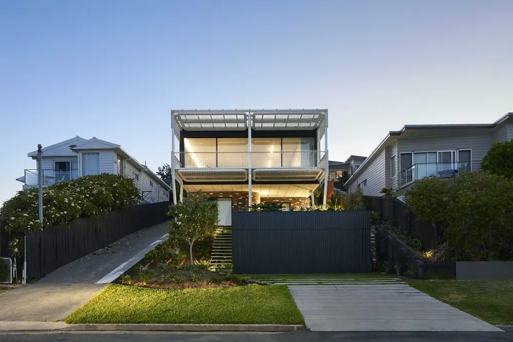 Greenacres House stands on a steeply sloping site in a Newcastle neighborhood.